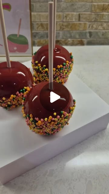 Glossy red candy apples rimmed with rainbow sprinkles